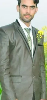 A man in a suit standing in green fields.