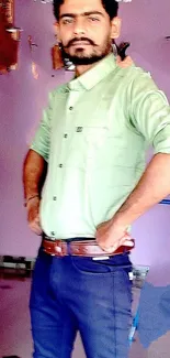 Stylish man in a green shirt with a lilac background.