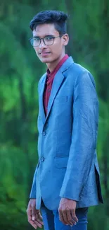 Portrait of a person in a blue suit with green foliage background.