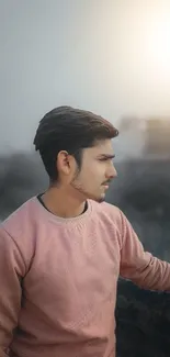 Young man in pink sweater at sunset.