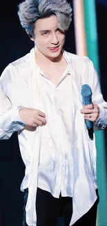 Stylish man in a silk white shirt holding a microphone with colorful background.