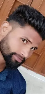 Stylish young man with beard against a brown textured background.