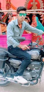 Man in sunglasses on a motorcycle with vibrant cultural backdrop.