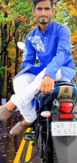 Man in blue traditional attire on a motorcycle in forest.