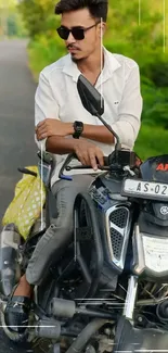 Man sitting on a motorcycle with a green background.