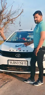 Man posing in front of white car on a sunny day.