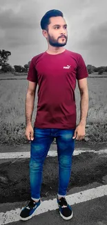 Man in red shirt and blue jeans standing outdoors.