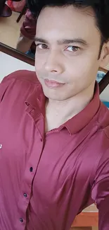 Stylish selfie with maroon shirt in casual pose.