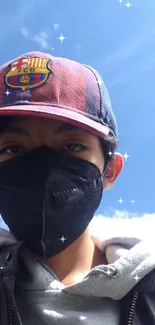 Boy with mask and cap under a bright sky.