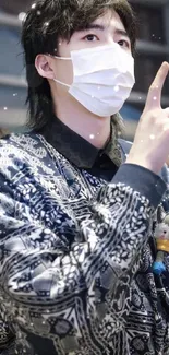 Fashionable individual in a patterned black and white shirt with a mask.