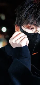 Stylish individual with glasses and black mask in a dark, urban setting.