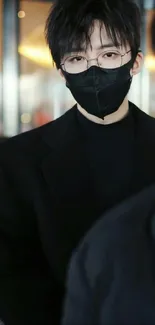 Person in a black mask and glasses with a stylish, dark aesthetic background.