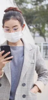 Woman in mask using phone with stylish urban background.