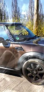 Brown Mini Cooper driving on a sunlit road.