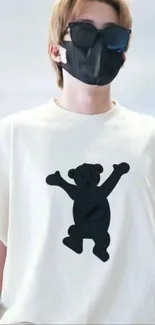 Person wearing a white t-shirt with a black bear design and sunglasses.