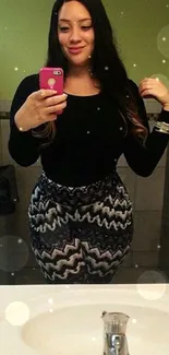 Fashionable woman takes a mirror selfie in stylish attire.