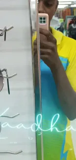 Mirror selfie with fashion and sunglasses display, vibrant yellow theme.