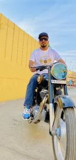 Motorcycle rider in a stylish urban setting with yellow wall.