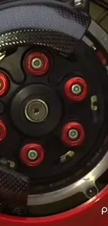 Detailed motorcycle wheel with red accents and black background.