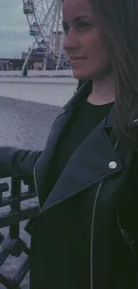 Stylish woman in a leather jacket by the cityscape at night.