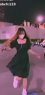 Person dancing at night with stylish outfit and urban backdrop.