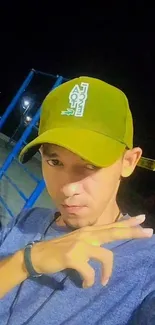 Person in olive cap posing at night with a stylish background.