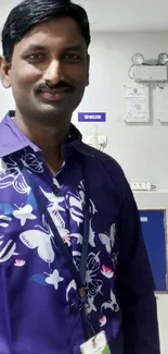 Man wearing a colorful shirt in an office setting.