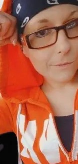 Person in an orange hoodie with glasses.