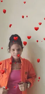 Woman in orange jacket against a wall.