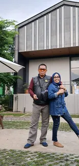 Couple posing outside modern building.