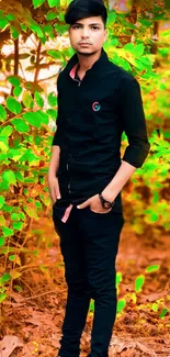 Stylish young man standing in a green leafy outdoor setting.