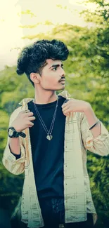 Young man in stylish outfit amidst greenery.