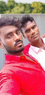 Stylish outdoor selfie with red shirt and nature backdrop.