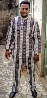 Stylish man in patterned outfit standing outdoors.