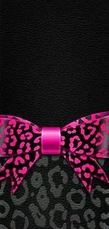 Pink bow on black leather with leopard print background.