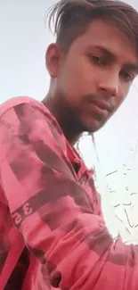 Young man in pink shirt with stylish look and soft background.