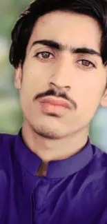 Blue shirt portrait with blurred natural background.