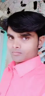 Portrait of a person in a pink shirt with tiled background.