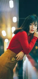 Urban night portrait of stylish woman leaning on railing.