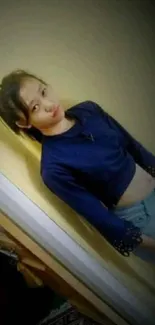 Young girl in casual attire posing indoors.