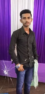 Young man posing in front of purple and white curtain.