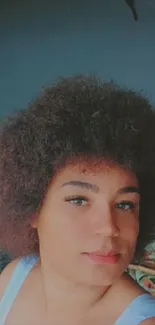 Stylish woman with curly hair in dark surroundings.