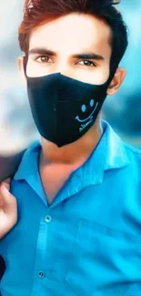 Person wearing a stylish black mask, blue shirt, artistic look.