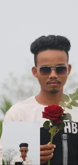 Man in sunglasses holding a red rose with a blurry natural background.