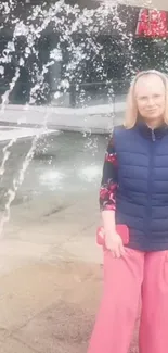 Person posing in front of urban water fountain, showcasing modern fashion.