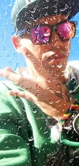 Stylish man behind raindrop covered glass with bright sky.