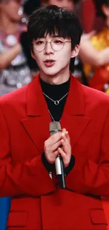 Man in a striking red blazer holding a microphone, fashion-forward style.