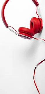 Red headphones on a white minimalist background.