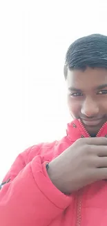 Young man in a red jacket against a bright background.