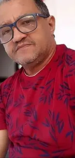 Man in a red shirt with blue leaf patterns.